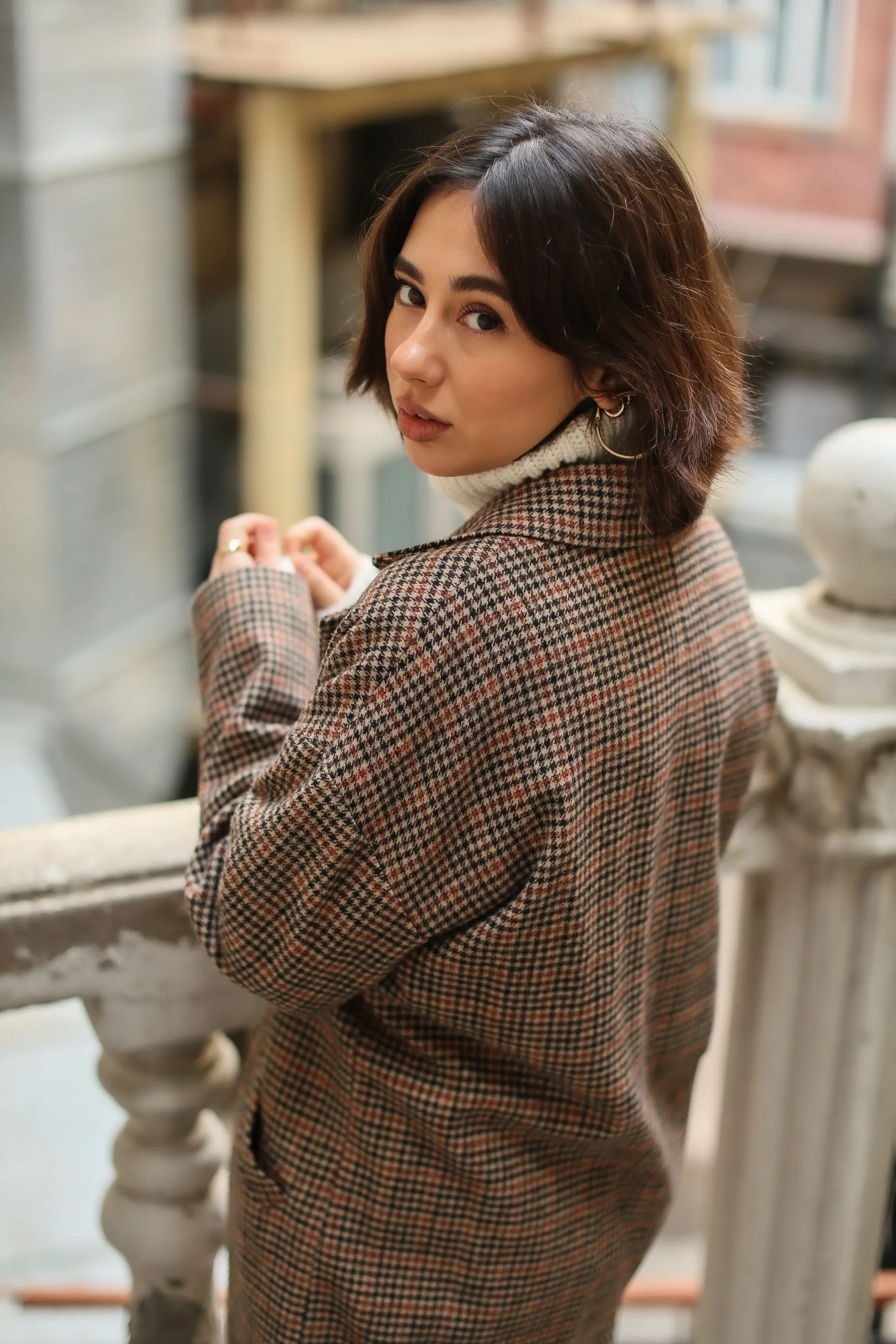 Woman in a check blazer on a vintage staircase